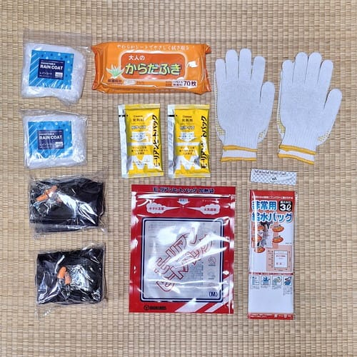 非常持出袋＿中身（レインコート、スリッパ、エアー枕、耳栓、からだふき、ヒートパック、吸水バッグ、軍手）